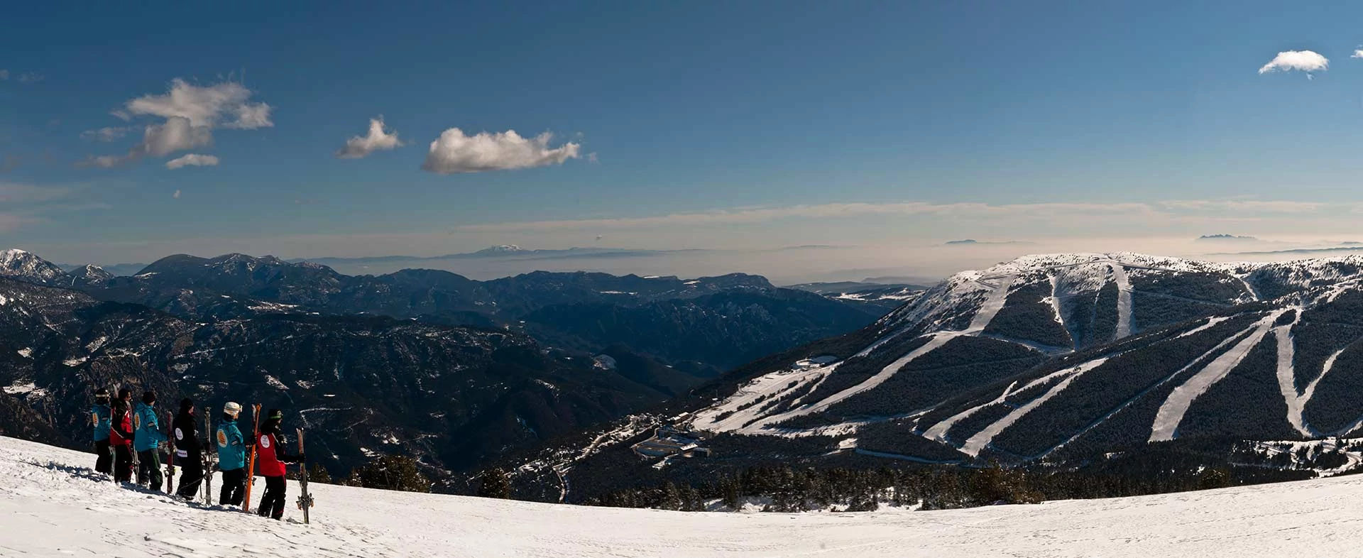 esquiadores olhando a montanha de neve